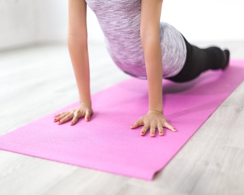 Person doing mindful yoga and relaxation exercises on a mat